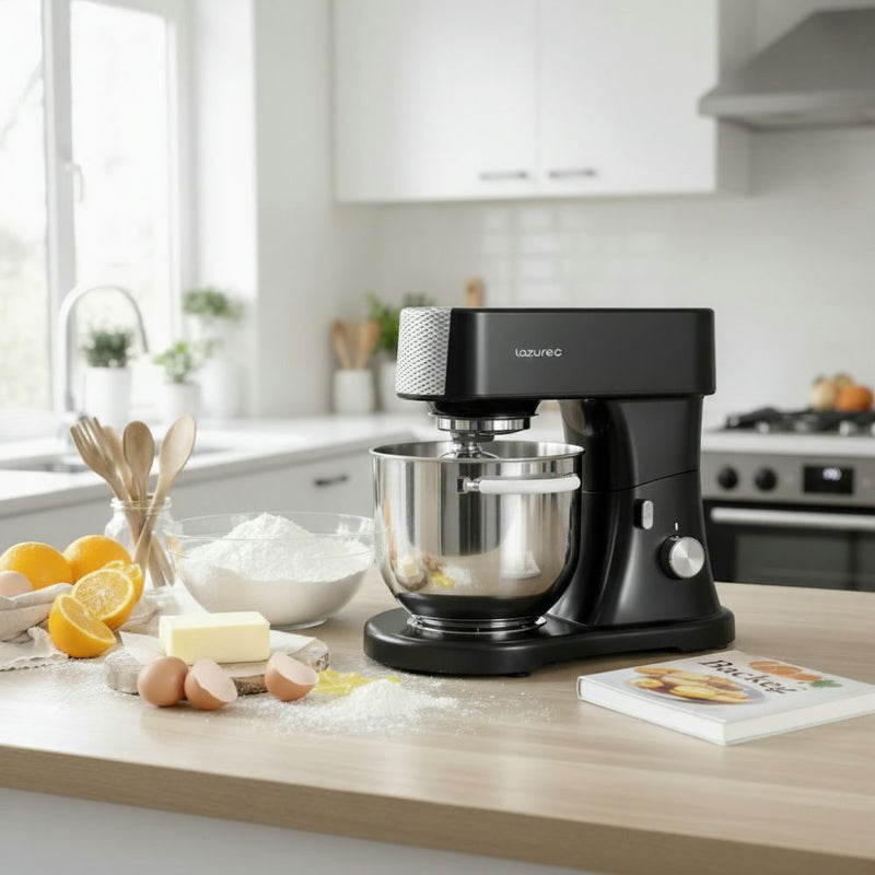 Küchenmaschine auf der Arbeitsfläche mit Zutaten wie Mehl, Eiern und Butter – ideal zum Backen und Kochen im Alltag.